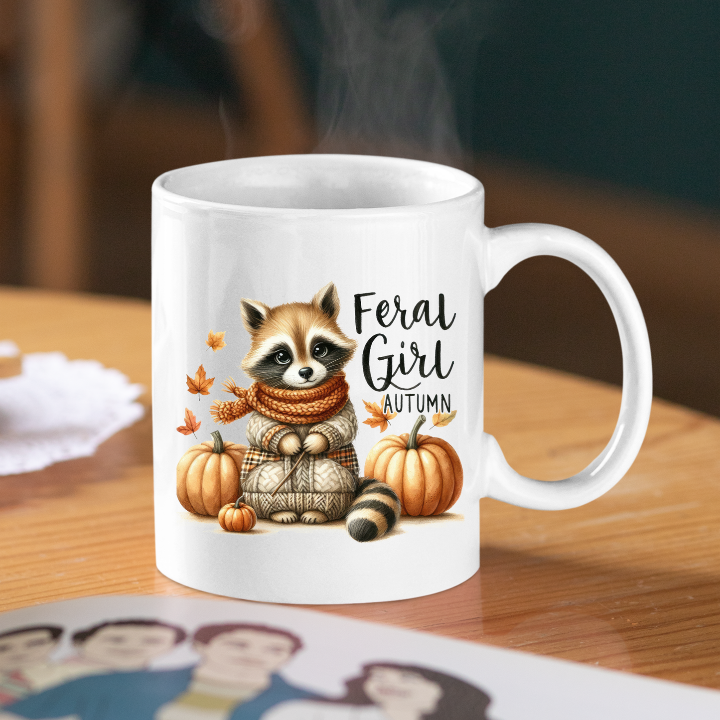 The Feral Girl Autumn Mug | Cozy Raccoon Fall Coffee Cup features a raccoon in a scarf surrounded by pumpkins and autumn leaves with the text “Feral Girl Autumn”—the perfect cozy mug for fall vibes.