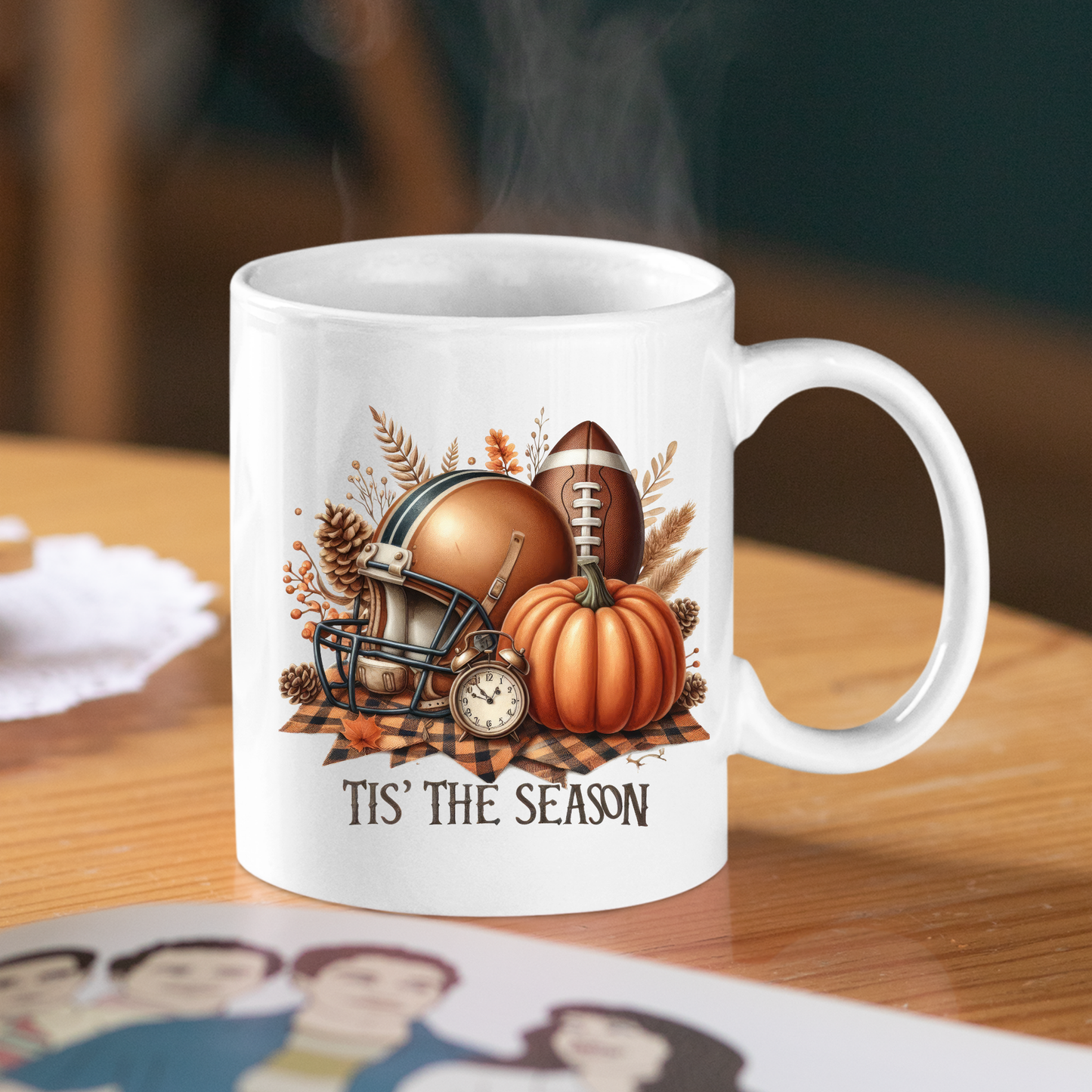 The "Tis' the Season Football Mug | Fall Pumpkins & Game Day Vibes" features a football helmet, pumpkin, autumn leaves, and the text "TIS' THE SEASON"—a cozy fall mug perfect for enjoying game day coffee.
