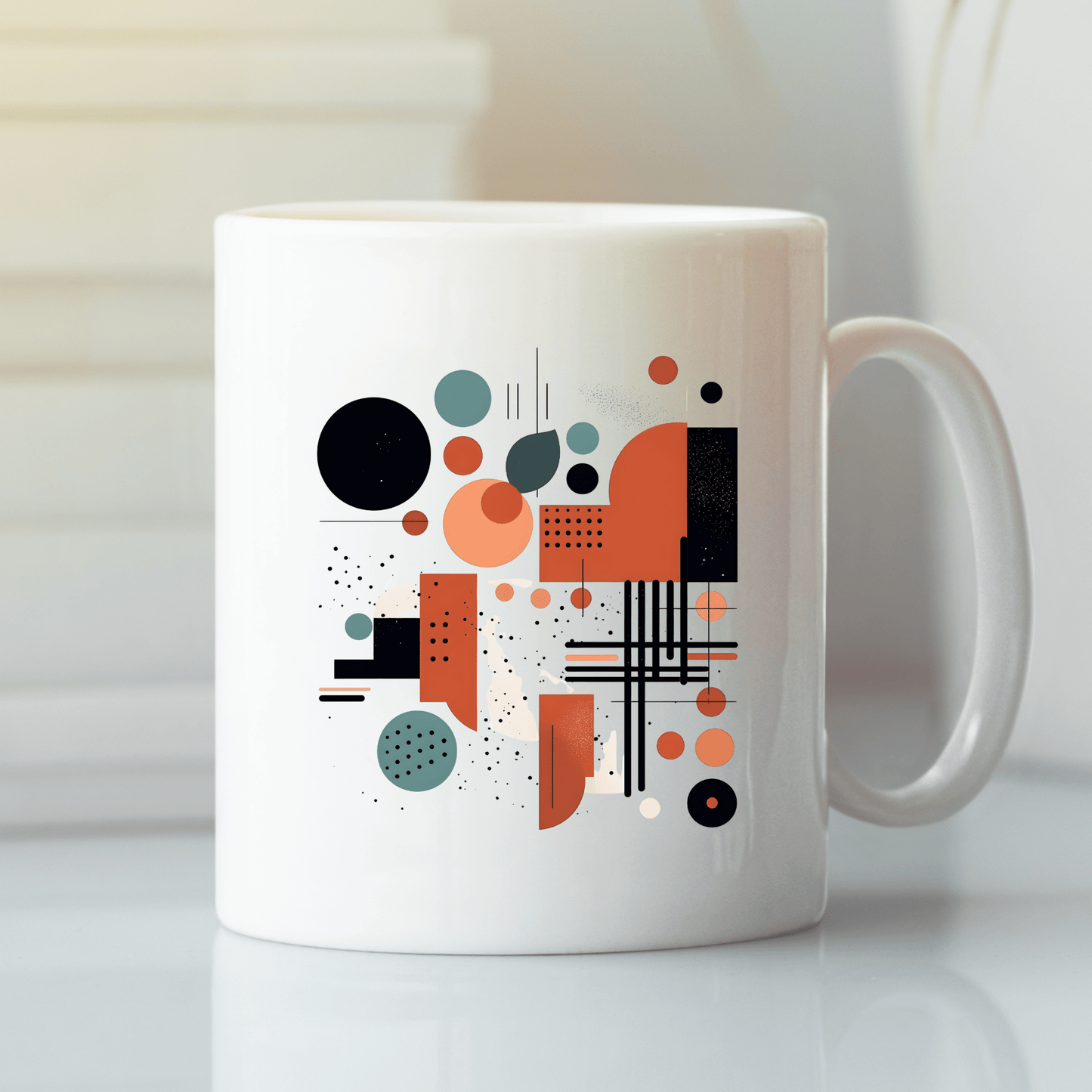 The Atomic Sunrise Mid Century Modern Mug is a white ceramic mug with a glossy finish, featuring an abstract geometric mid-century design in black, orange, and teal shapes—circles, rectangles, lines, and dots.