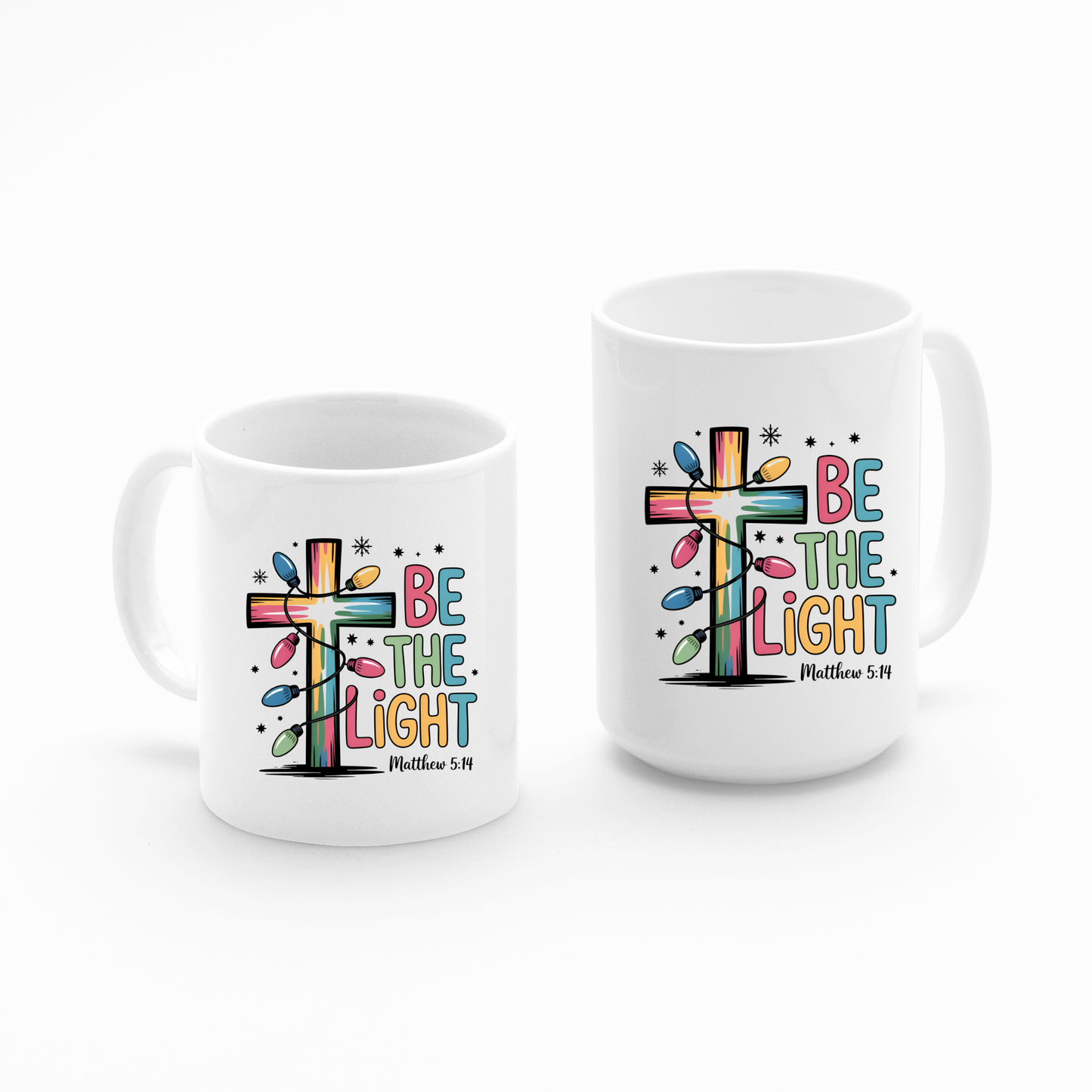 The Be the Light Matthew 5:14 Christmas Mug is a white Christian coffee mug featuring a colorful splashed cross, the phrase "Be the Light," and "Matthew 5:14" in decorative fonts.
