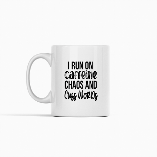 The Caffeine Chaos Cuss Words Mug is a white ceramic mug with "I RUN ON CAFFEINE, CHAOS AND CUSS WORDS" in bold black letters—a hilarious coffee gift for sarcasm lovers, shown on a plain white background.
