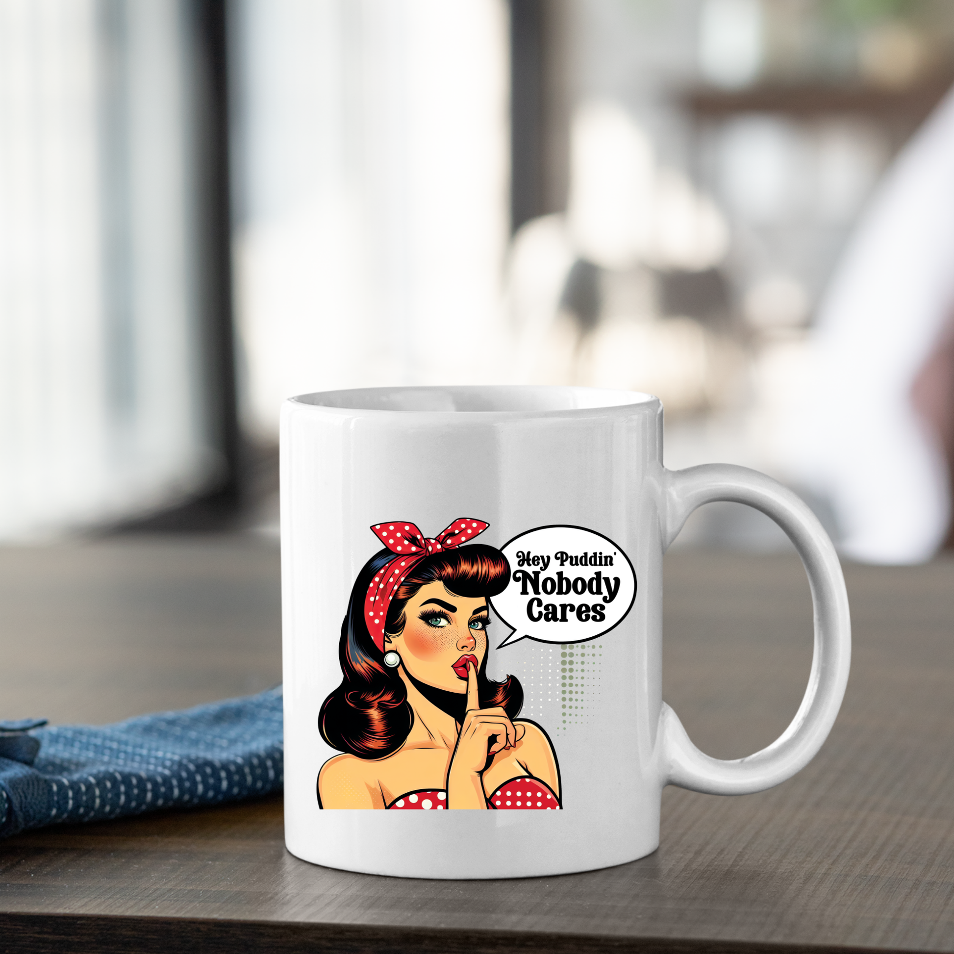 The Hey Puddin’ Nobody Cares Mug | Retro Pop Art Funny Gift features a woman with red lipstick and a polka-dot headband, holding a finger to her lips by a speech bubble saying, “Hey Puddin’ Nobody Cares”—the perfect funny mug or sarcastic gift.