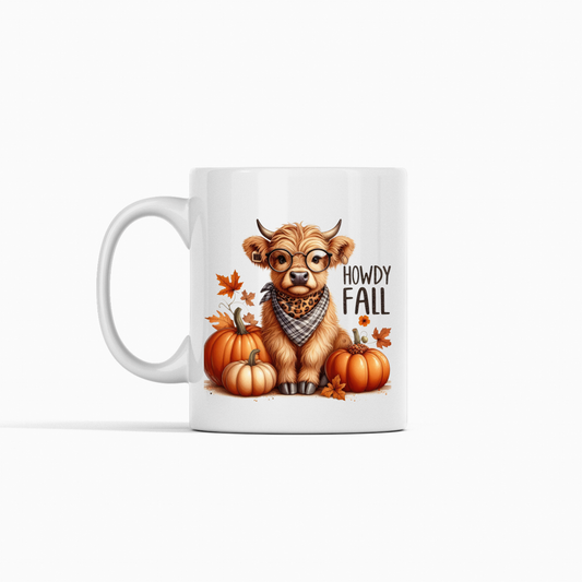 The Howdy Fall Mug | Highland Cow Autumn Coffee Cup features a cute cow in glasses and bandana among pumpkins and fall leaves—perfect farmhouse decor for cozy autumn days.