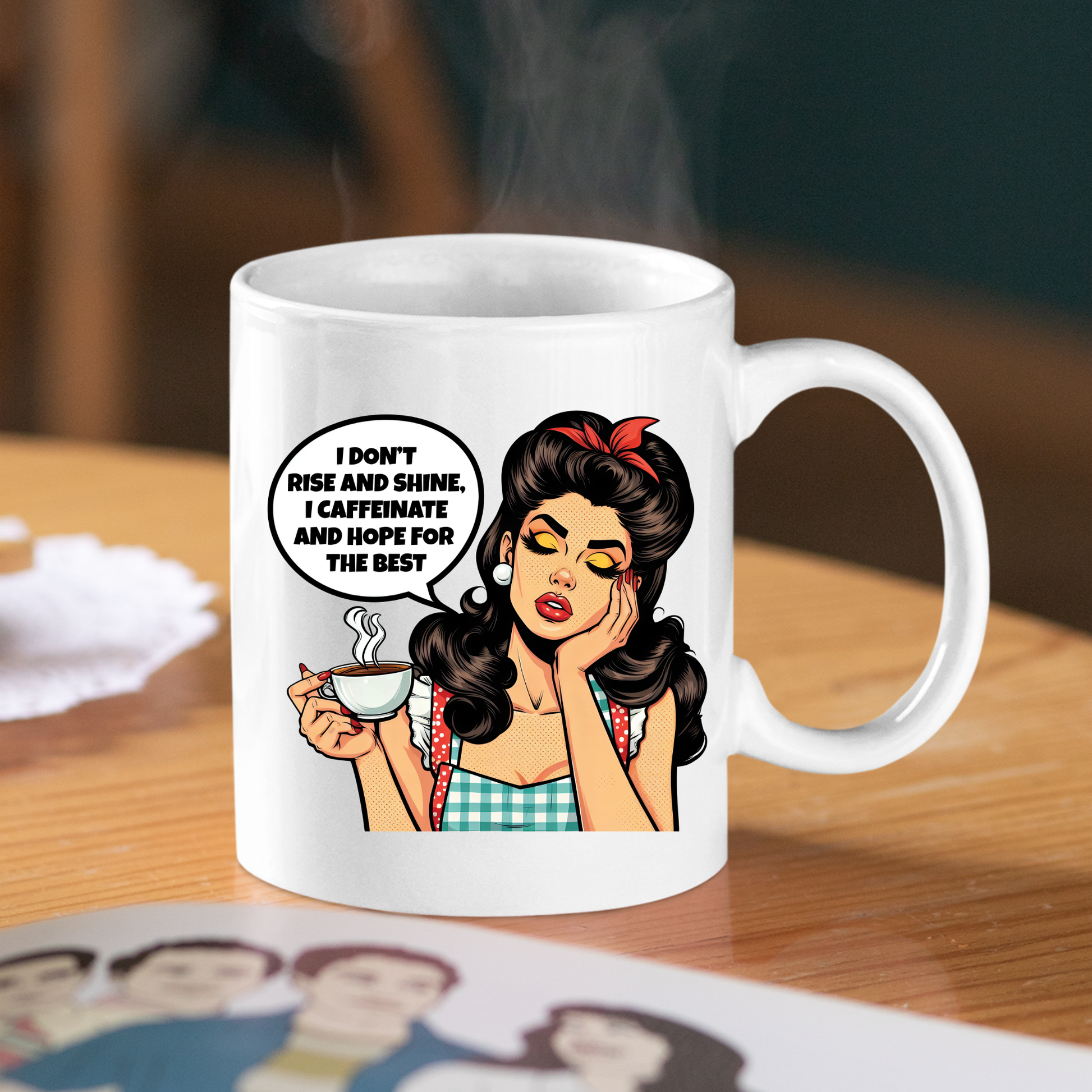 The Rise and Shine Caffeinate Mug is a white coffee cup featuring a retro pop art cartoon of a tired woman with the quote, "I don't rise and shine, I caffeinate and hope for the best." A perfect funny gift for coffee lovers.