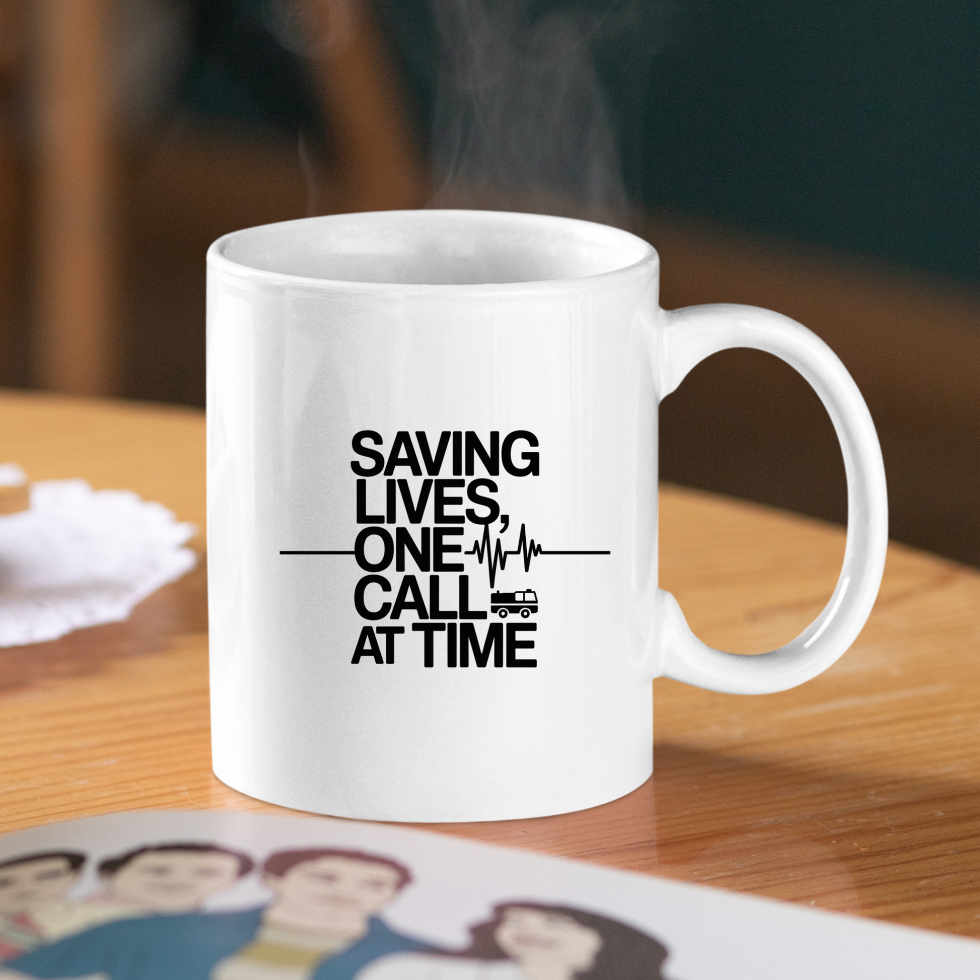 The Saving Lives One Call at a Time EMT Mug features the phrase “Saving lives, one call at a time” alongside a small ambulance graphic on its white surface. Perfect for paramedics and EMTs, this mug sits stylishly on a wooden table with steam curling from the top—a thoughtful gift for those devoted to saving lives every day.