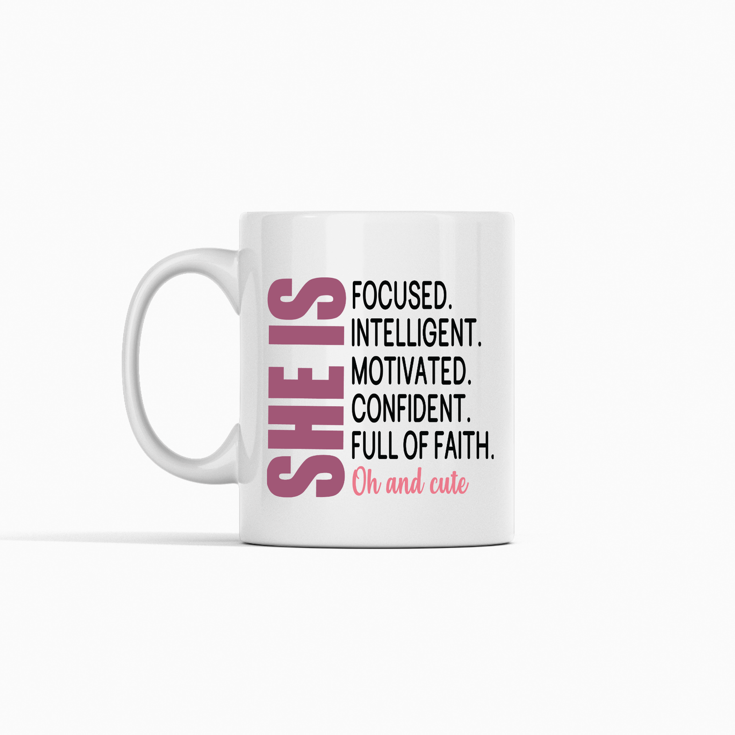 The She Is Mug | Motivational Gift for Women of Faith features bold pink "SHE IS" text and empowering words in black and pink—a perfect inspirational coffee cup gift for women.