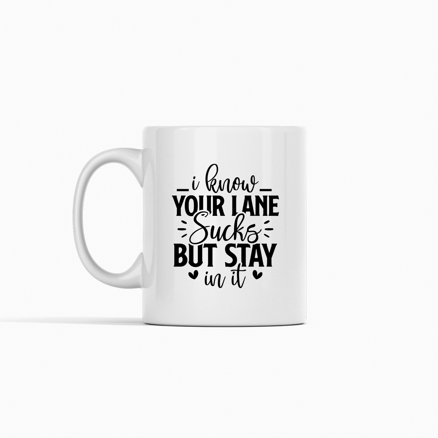 The Stay In Your Lane Mug – Funny Sass Coffee Cup is a white mug with black text that says, "I know your lane sucks but stay in it," plus heart and line accents—ideal as an office gift or for fans of sassy, mind-your-own-business mugs.